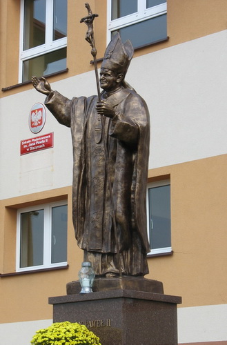 Pomnik Jana Pawła II przed budynkiem szkoły w Olszynach